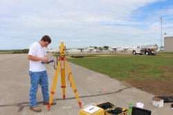 Student sets up surveying equipment